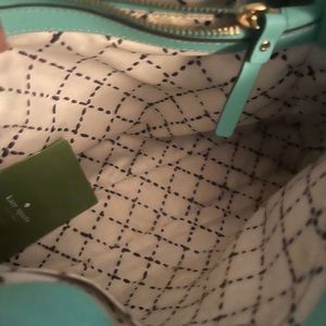 Teal Kate Spade purse with should strap